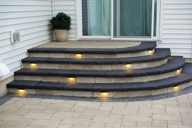 Black sandstone curved steps with inset lighting at a residential home entrance