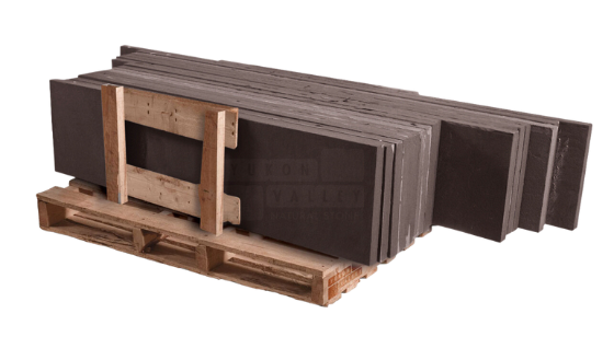 Black sandstone natural stone treads stacked on a wooden pallet for outdoor staircases
