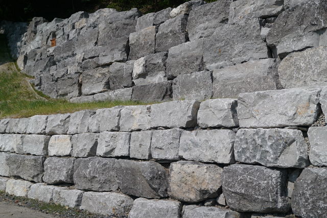 Tiered limestone boulder retaining wall with grey and tan color variations
