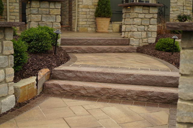 Brownstone natural stone steps and curved walkway at a residential home entrance