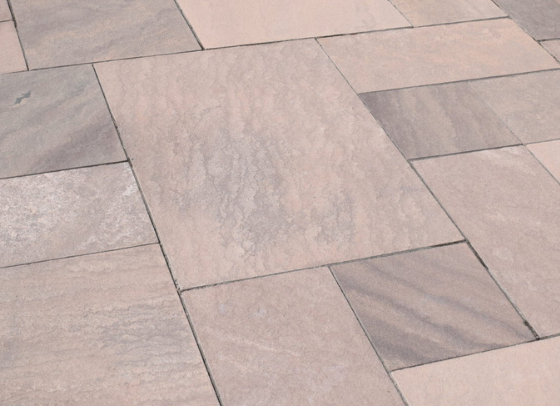 Brownstone pattern cut natural stone installed as a patio with mixed-size rectangular slabs