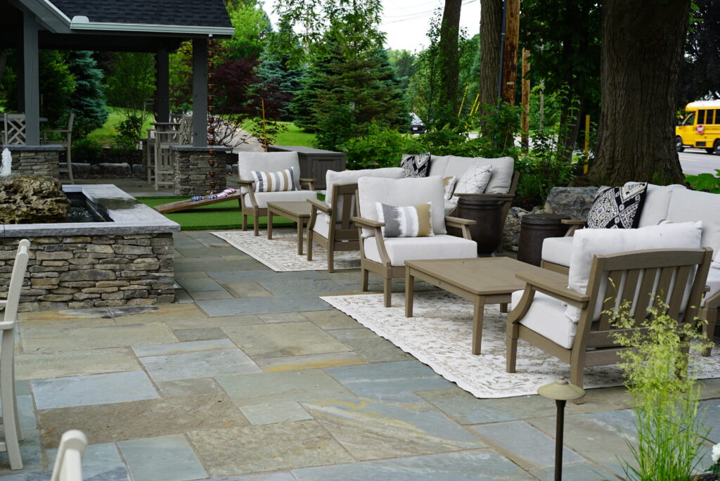 Bluestone flagstone patio with outdoor lounge furniture, water feature, and stacked stone walls