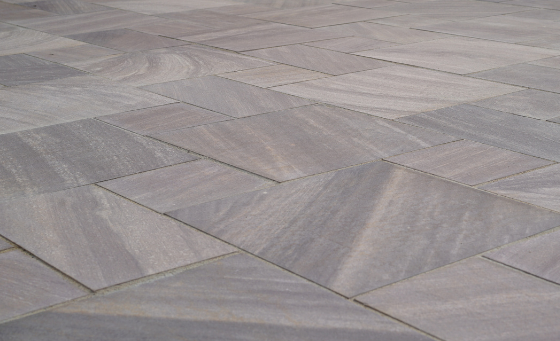 New brownstone pattern cut natural stone installed as a patio with mixed-size rectangular slabs