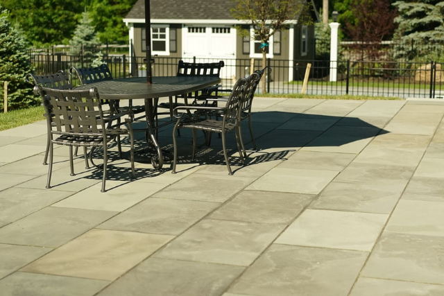 Bluestone pattern cut patio with mixed-size rectangular pavers and outdoor dining set