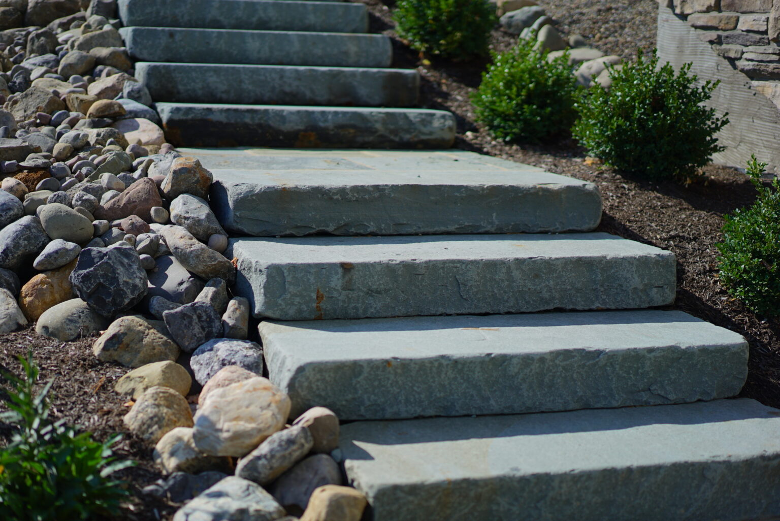 Natural stone steps installed as an outdoor staircase in a residential landscape project