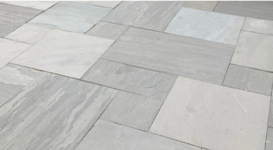 Slate grey natural stone pattern cut installed as a patio with mixed-size rectangular slabs