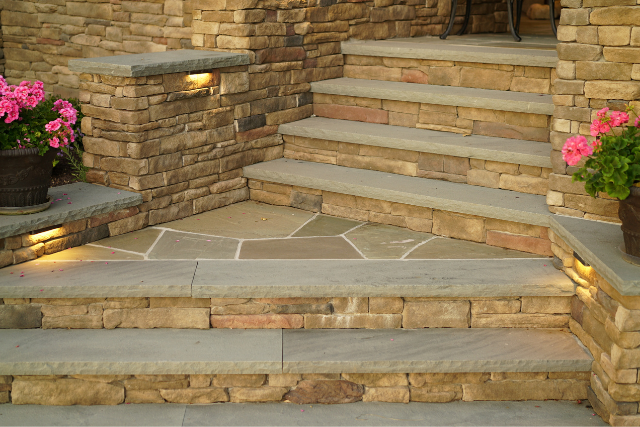 Natural stone treads with stone wall sides and flagstone landing in a garden entry