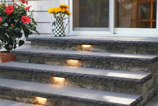 Black natural stone treads with inset lighting on an outdoor staircase